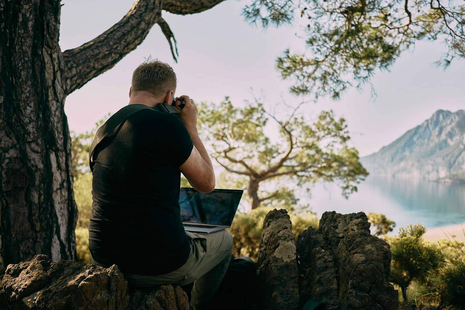 A person working on a laptop from a mountaintop, representing a business you can run from anywhere